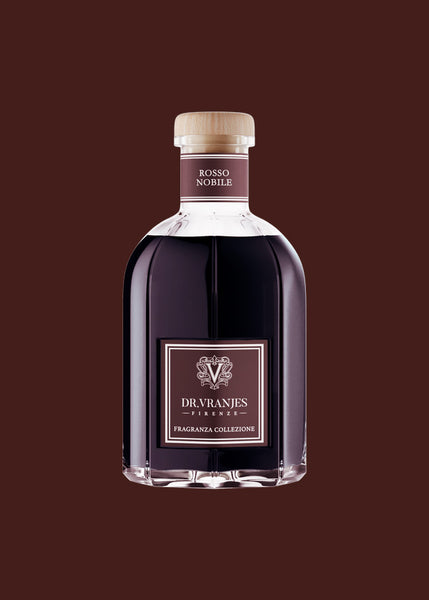A bottle of Dr Vranjes Firenze Rosso Nobile home fragrance reed diffuser, featuring a glass bottle filled with deep red home fragrance with a light wood cap and a maroon label, set against a solid burgundy background
