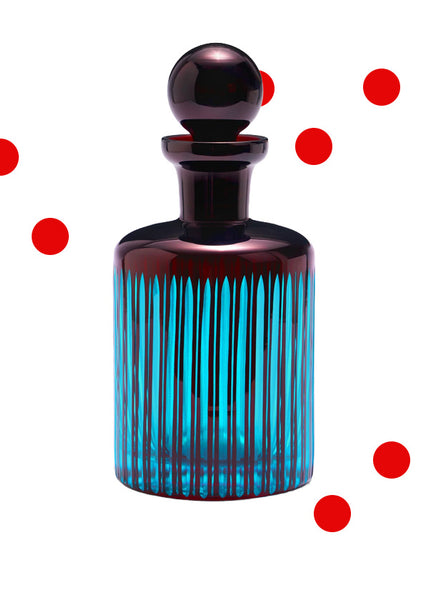 A dark purple cut-glass L'Objet Prism decanter with a matching spherical stopper, featuring vertical fluted ridges that glow with a bright turquoise blue light, set against a white background with scattered red dots.