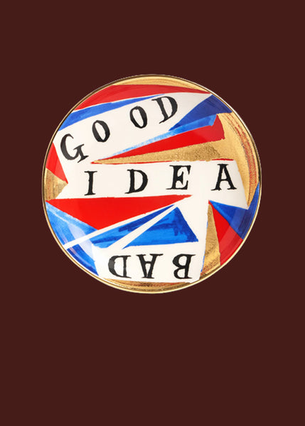 The words "good idea bad" are hand painted on this red, gold, blue and white hand made round ceramic plate.  The bad is written upside down so you can rotate the plate. The colours are organised in an abstract arrangement, with a 24 carat gold finish.